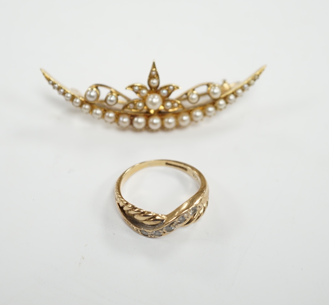 A yellow metal and seed pearl cluster set crescent shaped brooch, 48mm and a 9ct gold and cubic zirconia set ring, gross weight 10 grams.